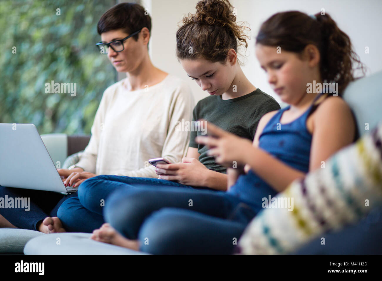 Family all using personal technology Stock Photo