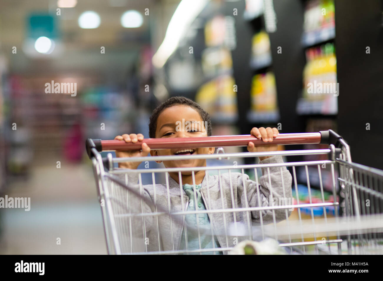 Young boy pushing trolley in grocery store Stock Photo