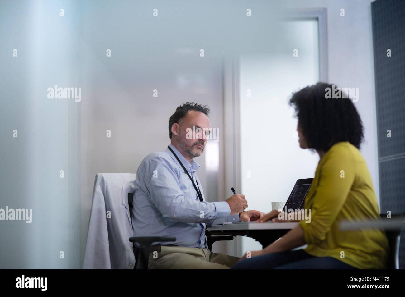 Male Medical Doctor taking notes of patient symptoms Stock Photo