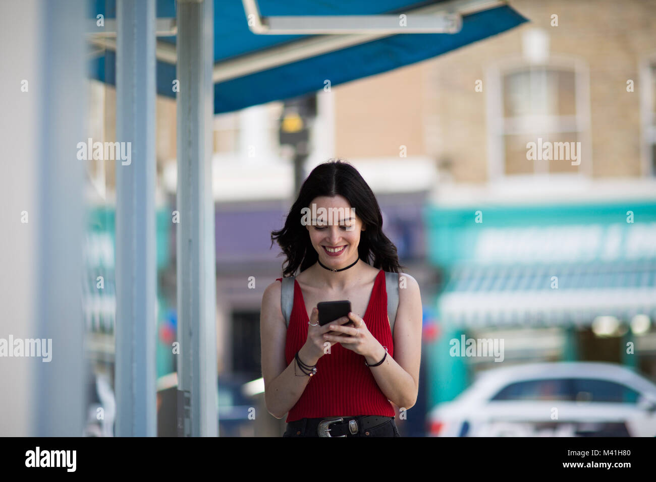 Young adult female using a smartphone whilst shopping Stock Photo