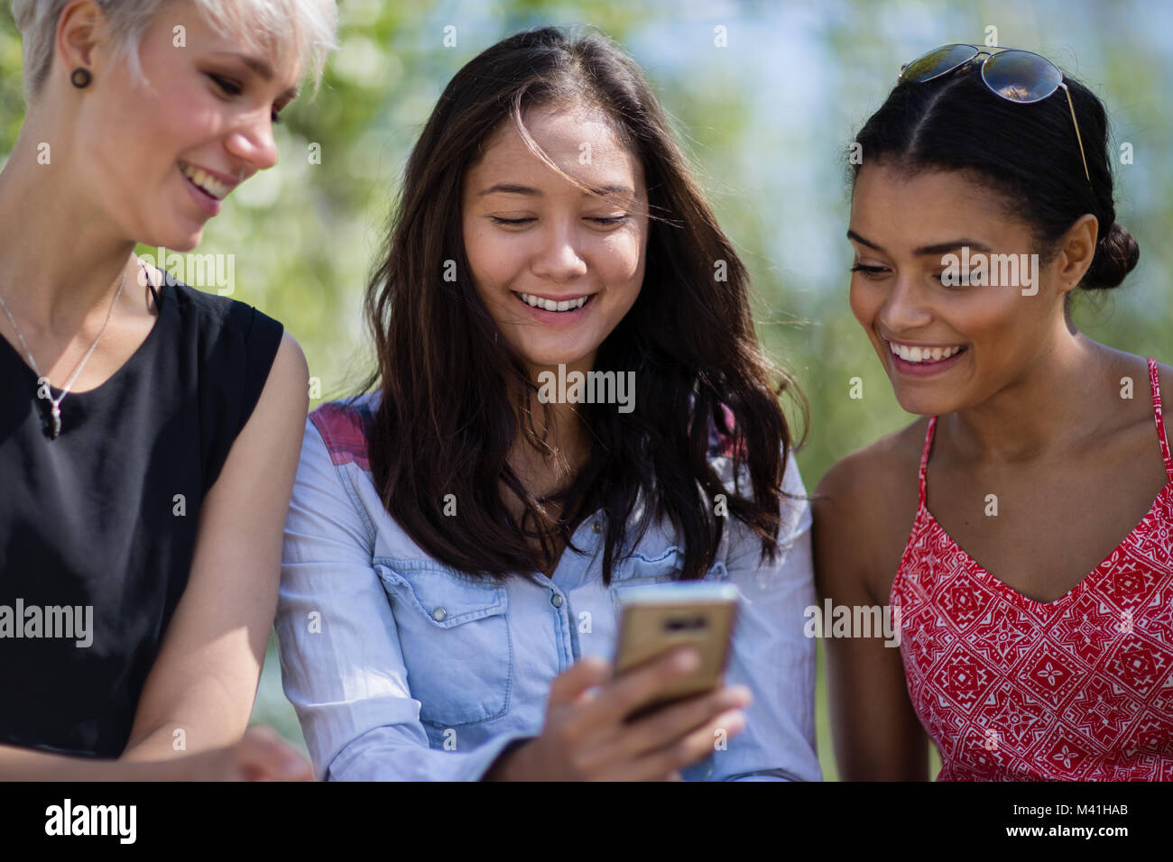 Female friends looking at smartphone Stock Photo