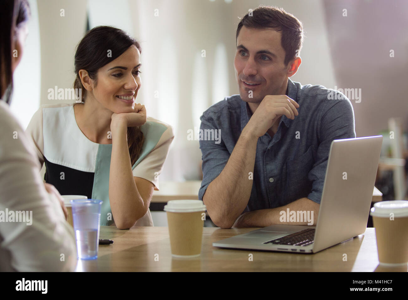 Colleagues in café looking at laptop Stock Photo