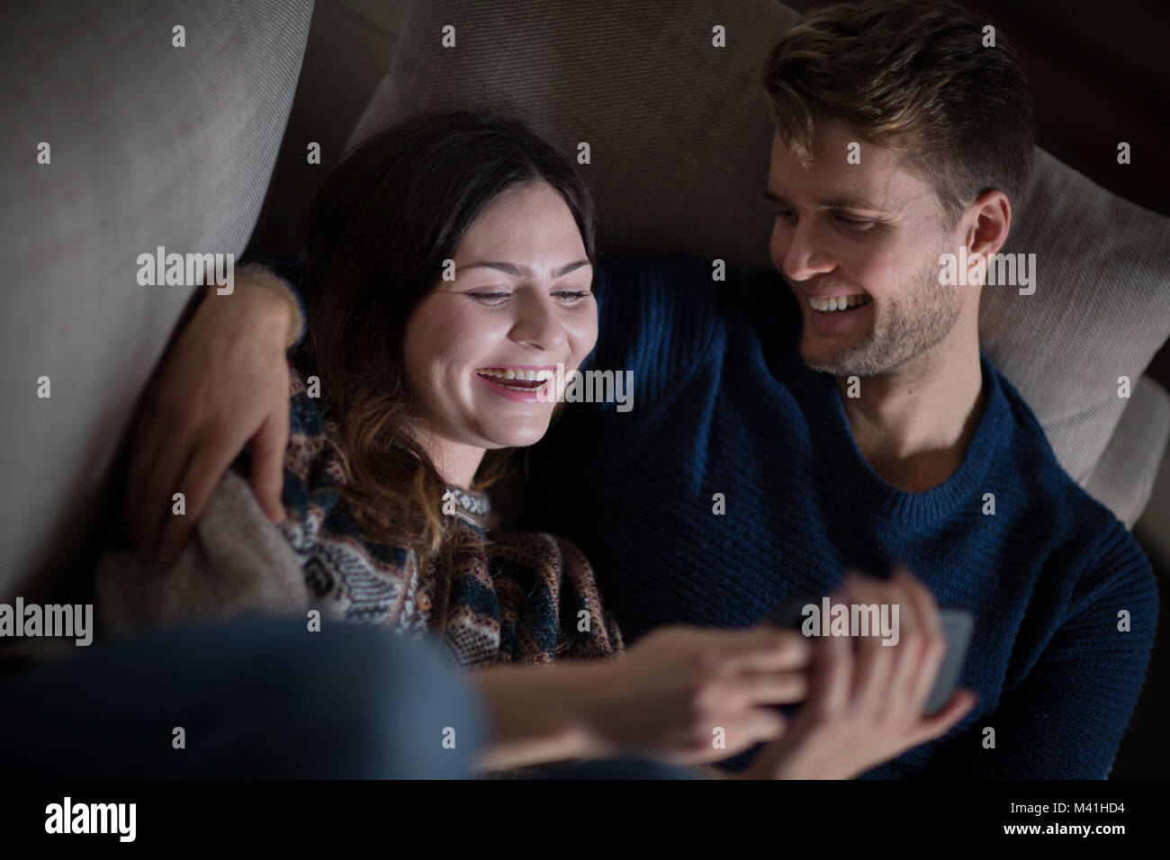 Couple looking at smartphone on sofa Stock Photo