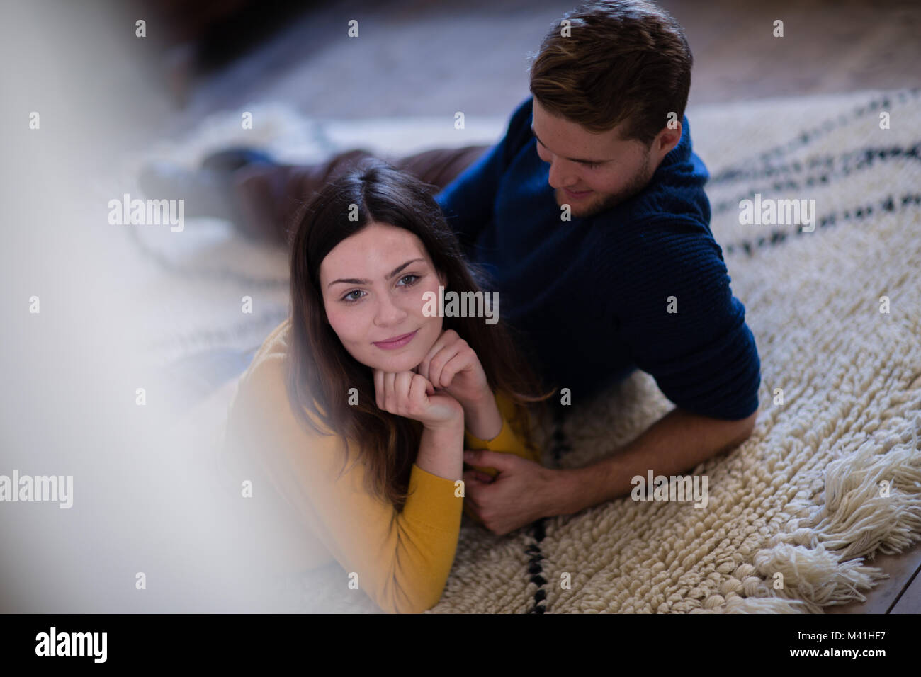 Couple lying on rug in new home Stock Photo
