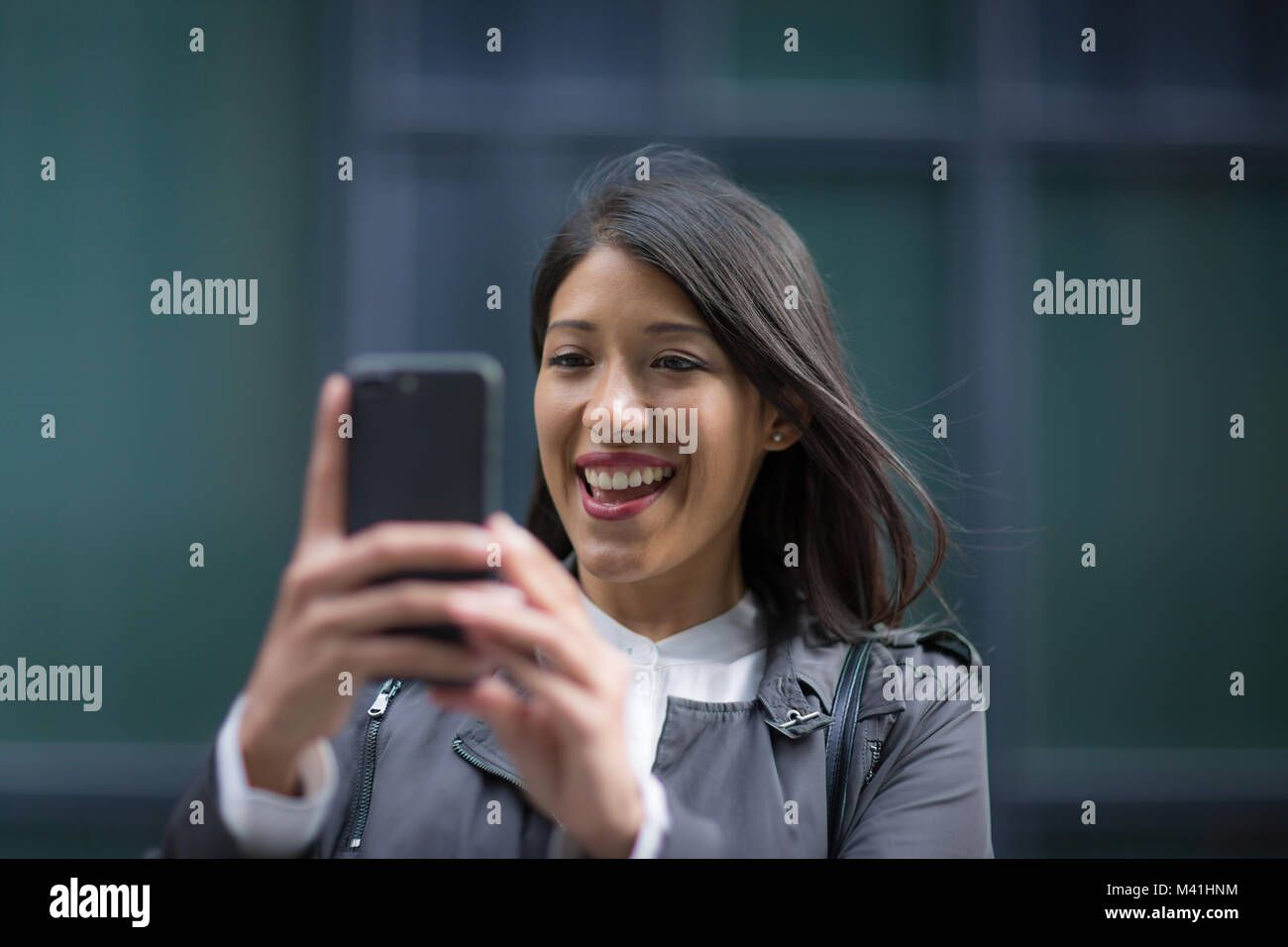 Smiling woman on video call outdoors Stock Photo