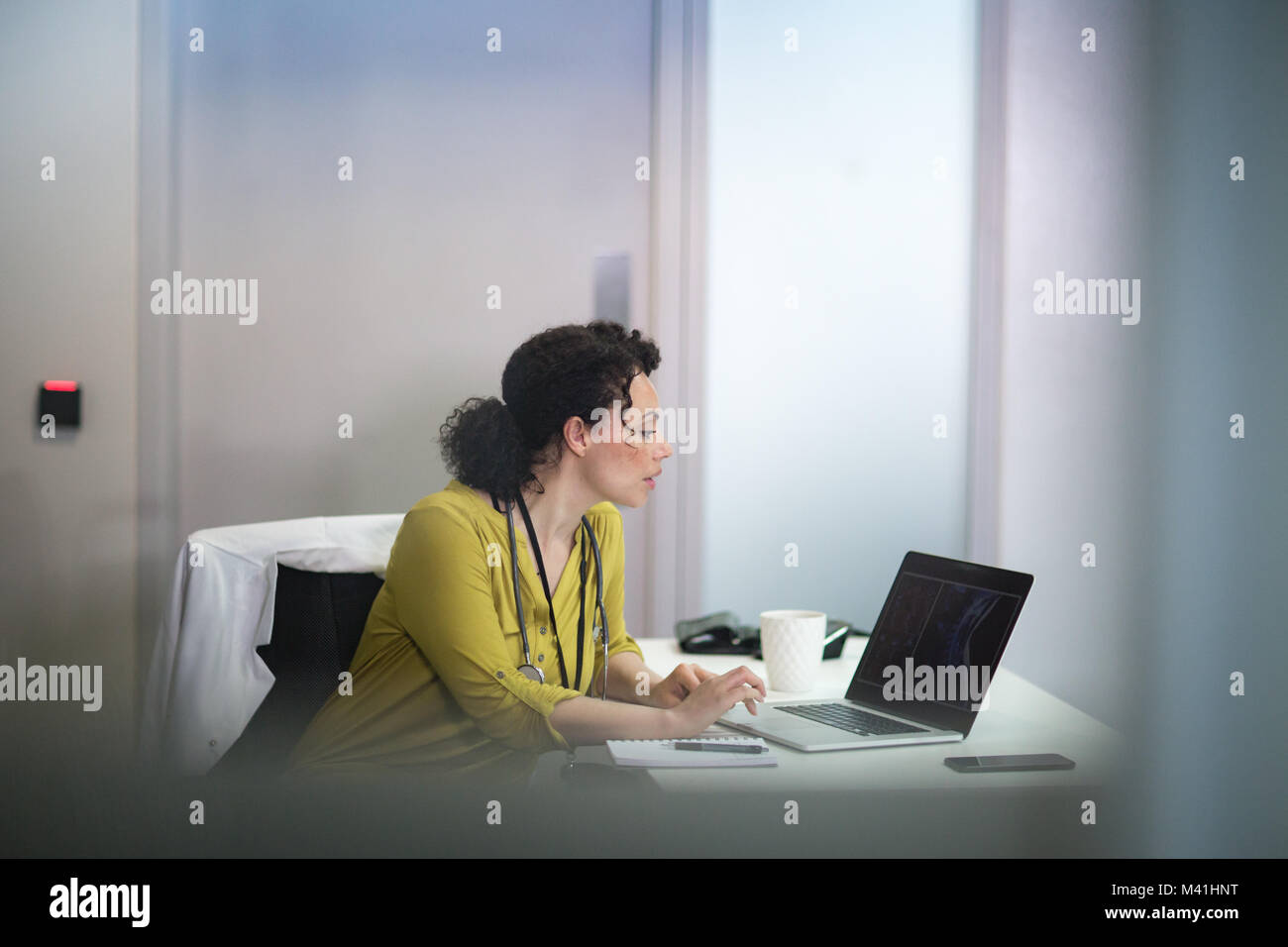 Female Medical Doctor looking at xray results on laptop Stock Photo