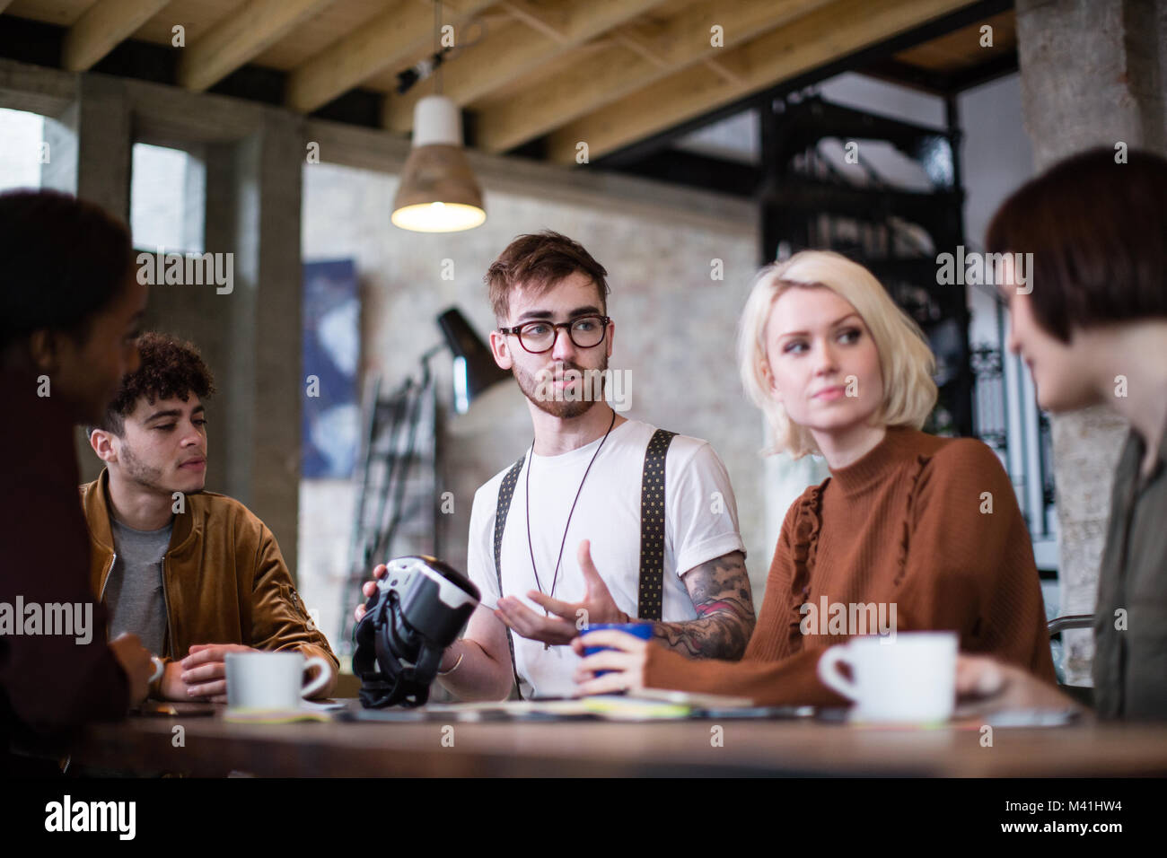 Group of young entrepreneurs in a meeting with VR headset Stock Photo