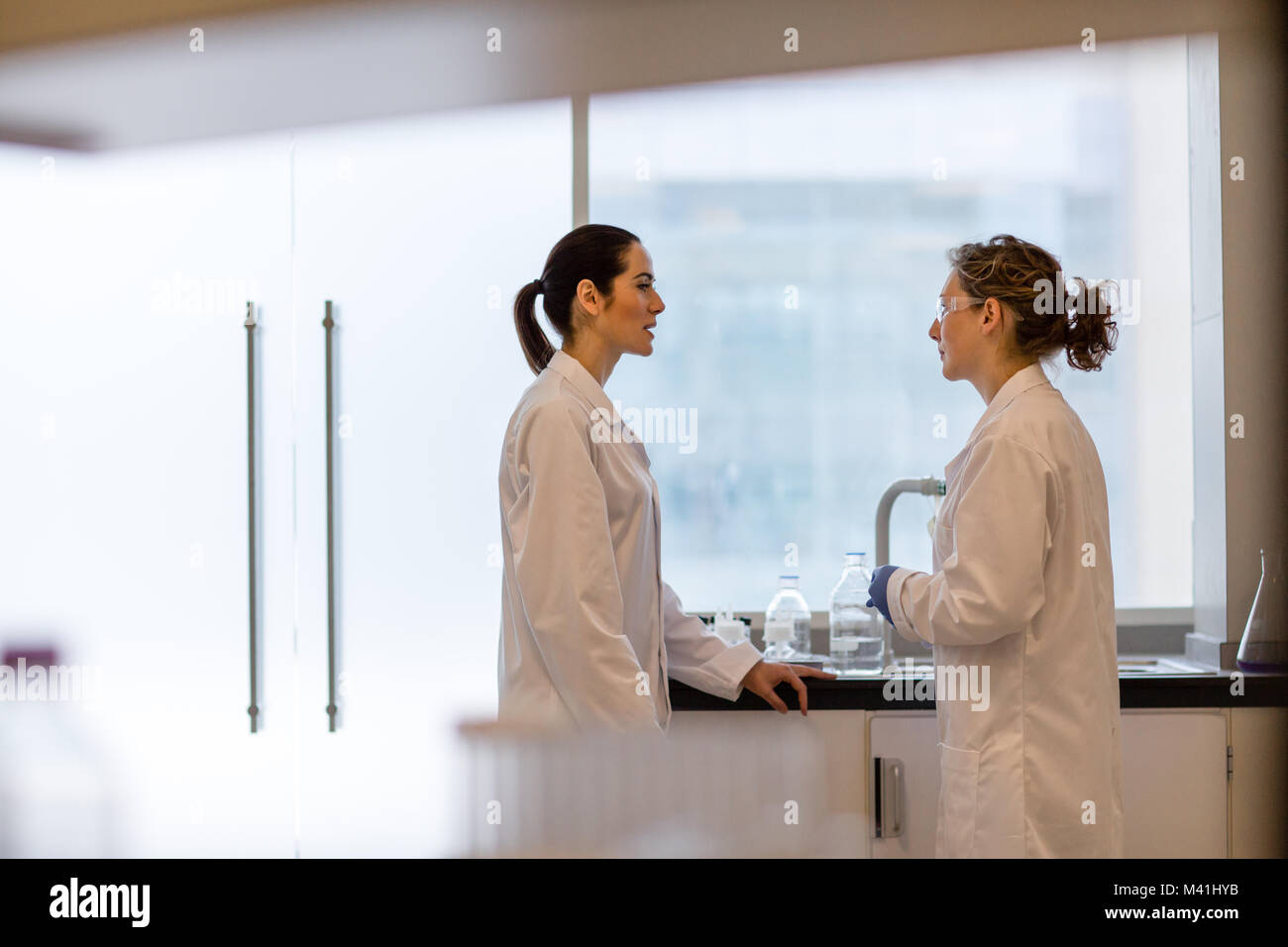 Two female scientists discussing results of experiment Stock Photo