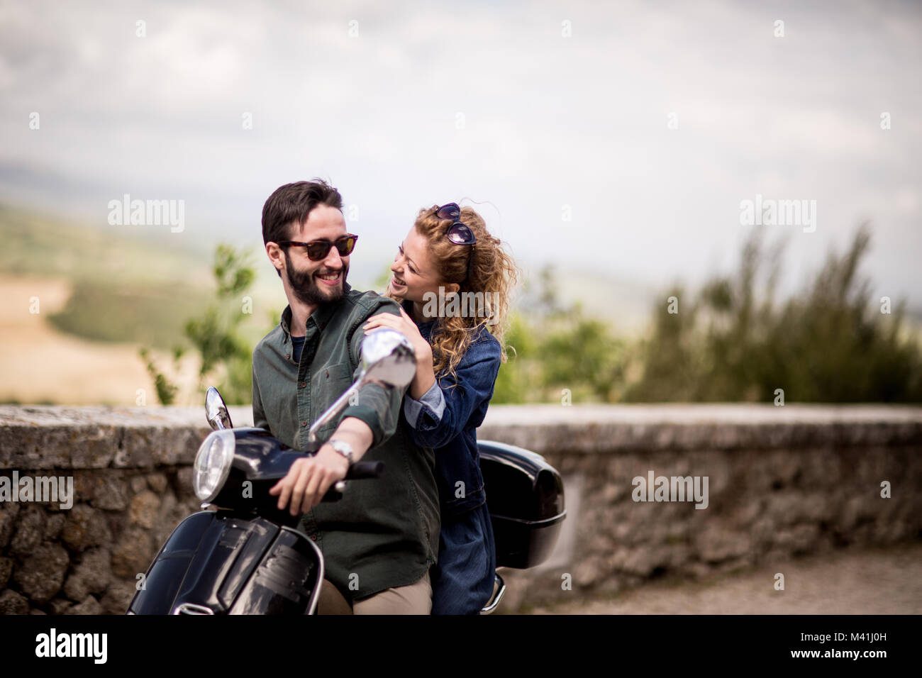 Young couple on motorbike together about to ride off Stock Photo