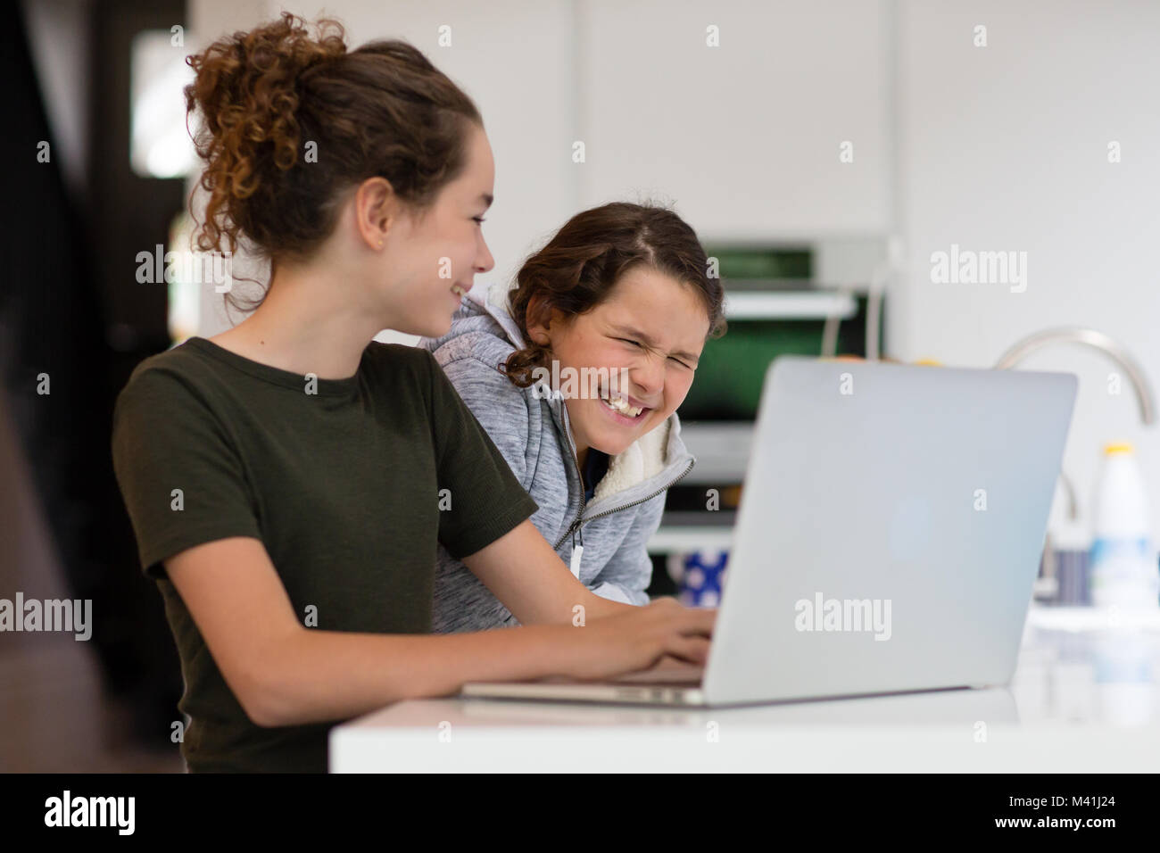 Sisters using laptop together Stock Photo