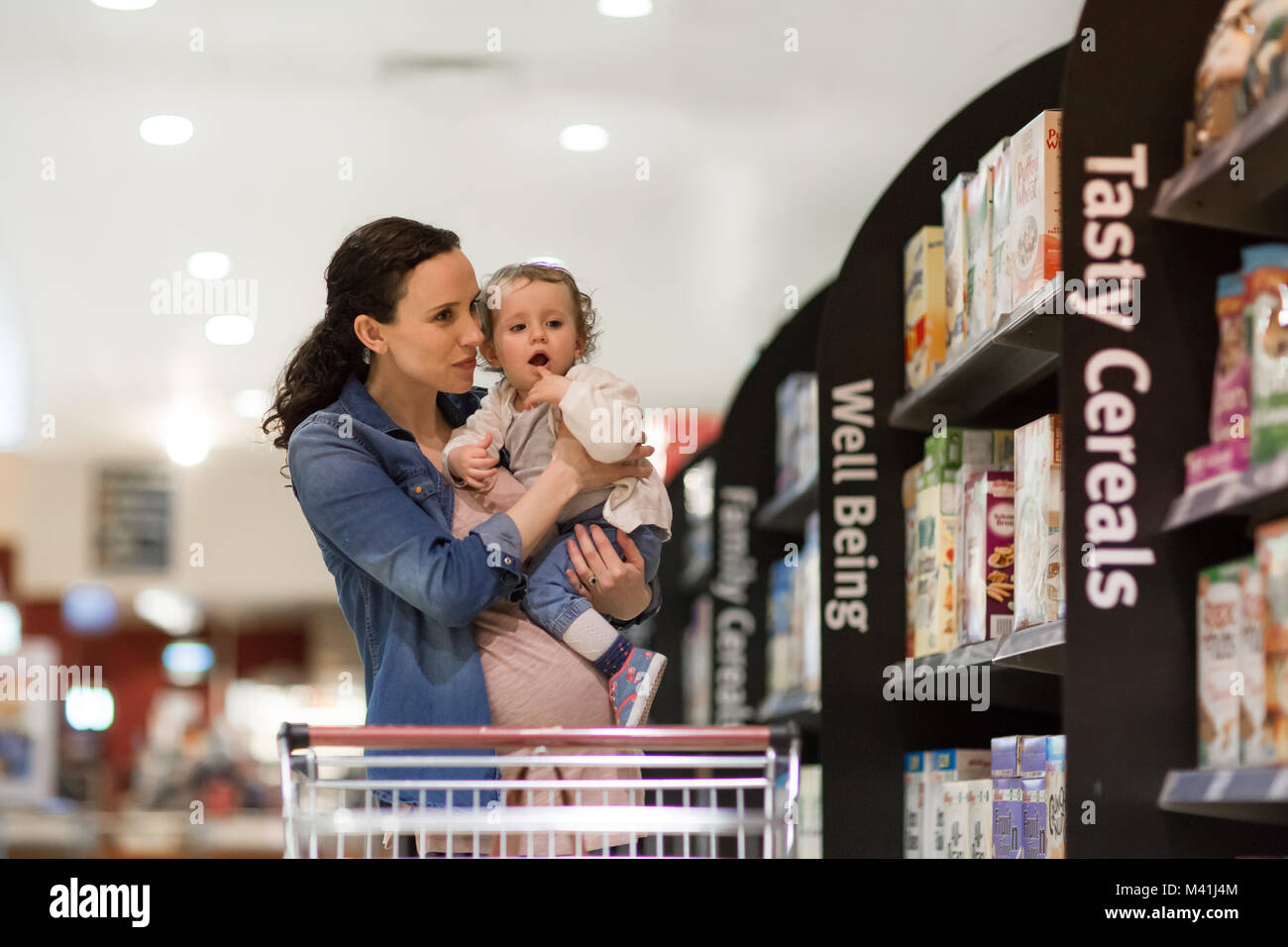 Pregnant mother with daughter grocery shopping Stock Photo