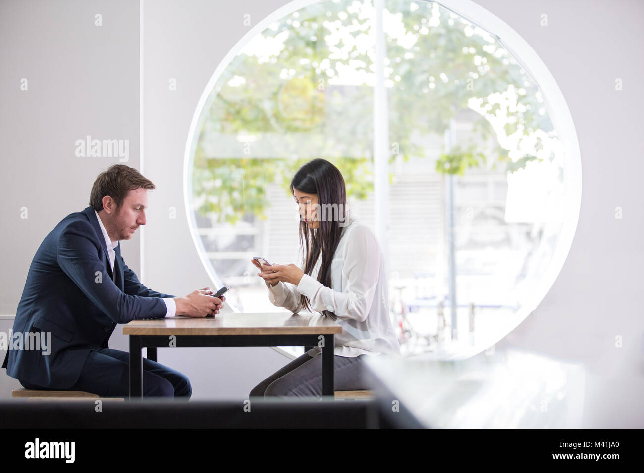 Colleagues using smartphone in an office Stock Photo