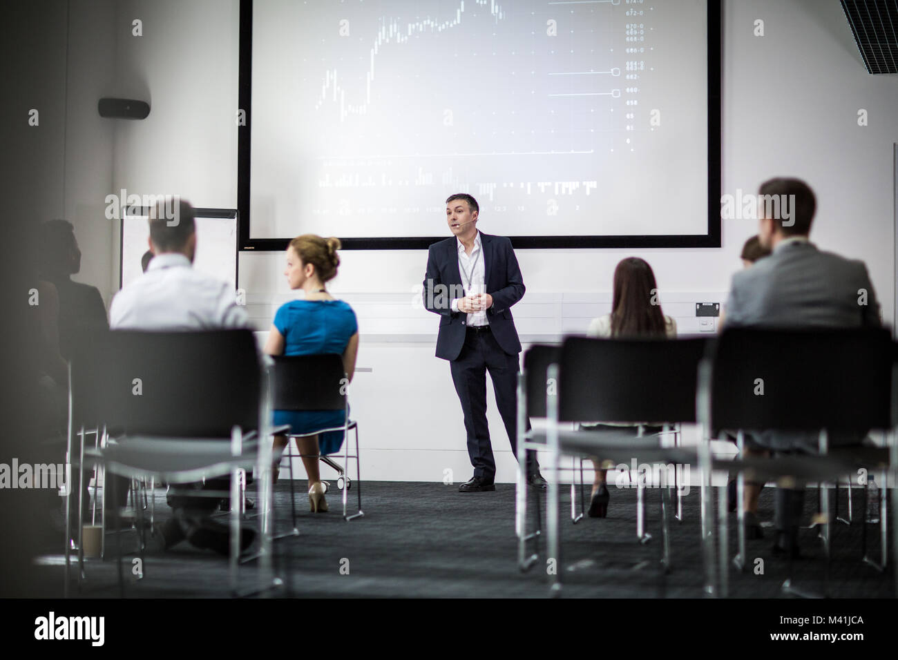 Speaker at a business training conference listening to a question Stock Photo