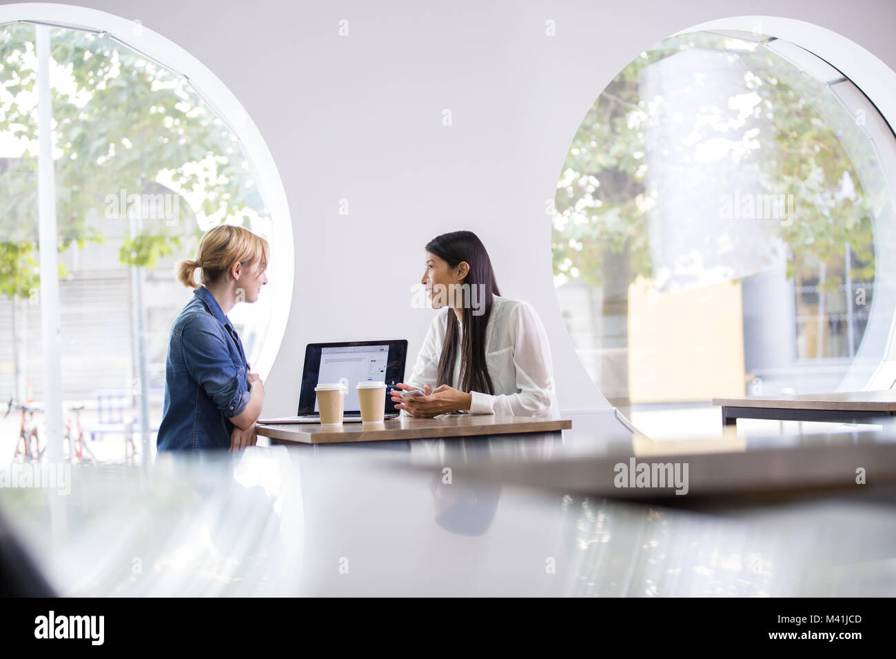 Female colleagues having a casual business meeting Stock Photo