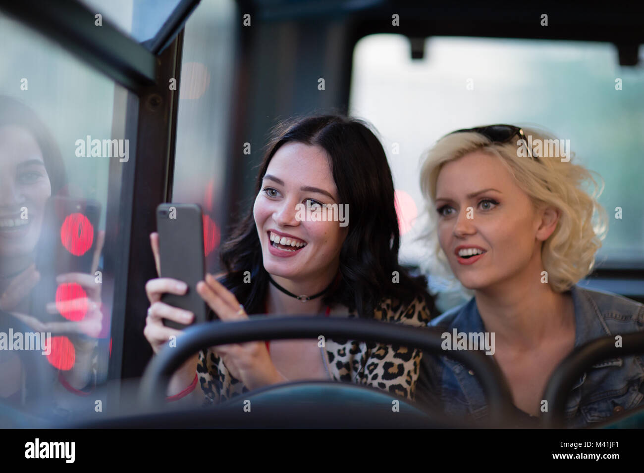 Female friends travelling through London on a bus Stock Photo - Alamy