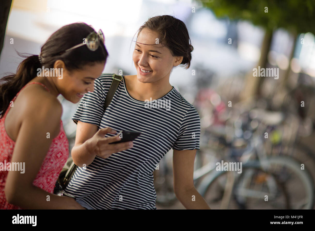 Students on way to college looking at smartphone Stock Photo