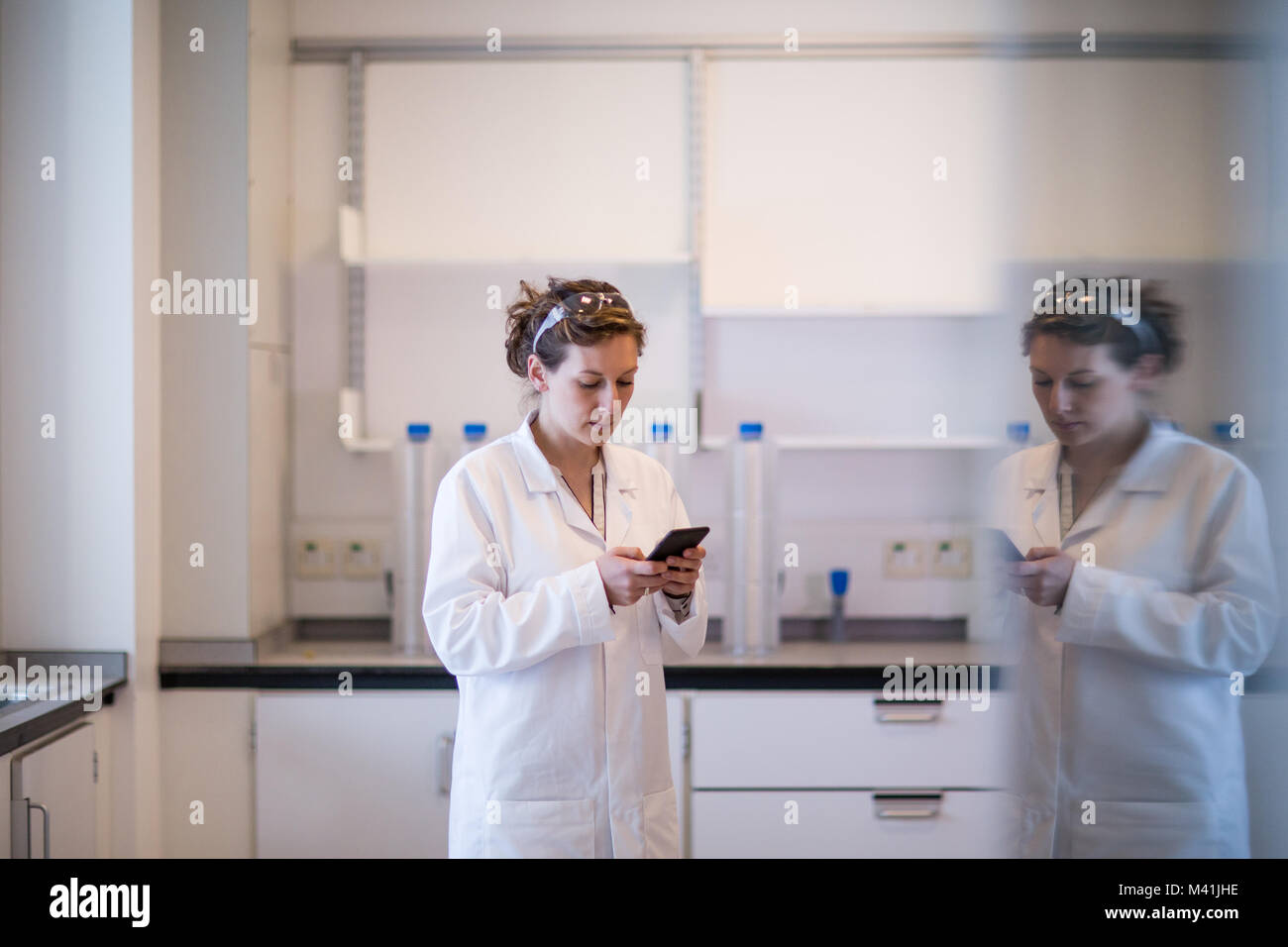 Female scientist using smartphone in laboratory Stock Photo
