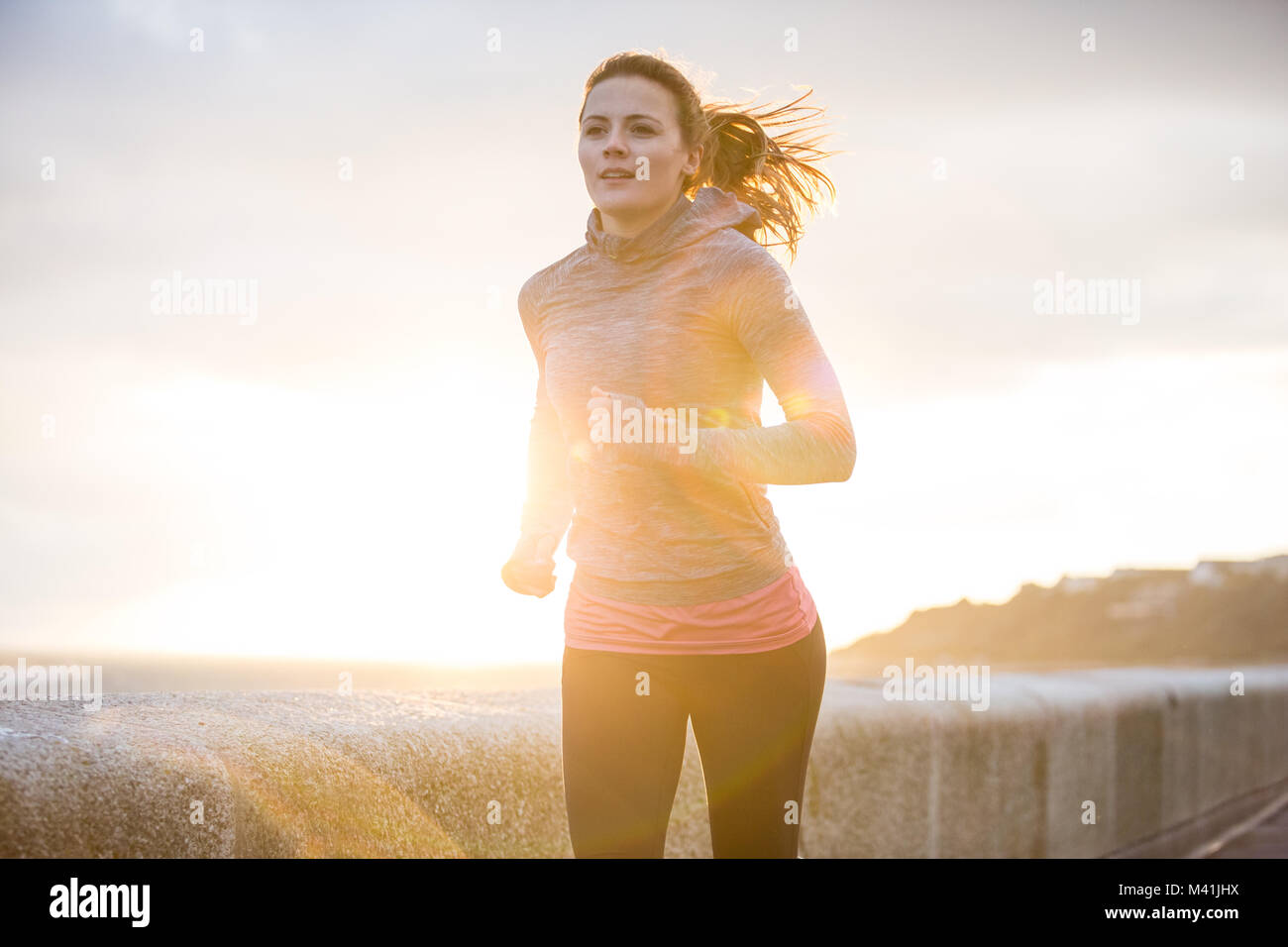 Young adult female running outdoors Stock Photo