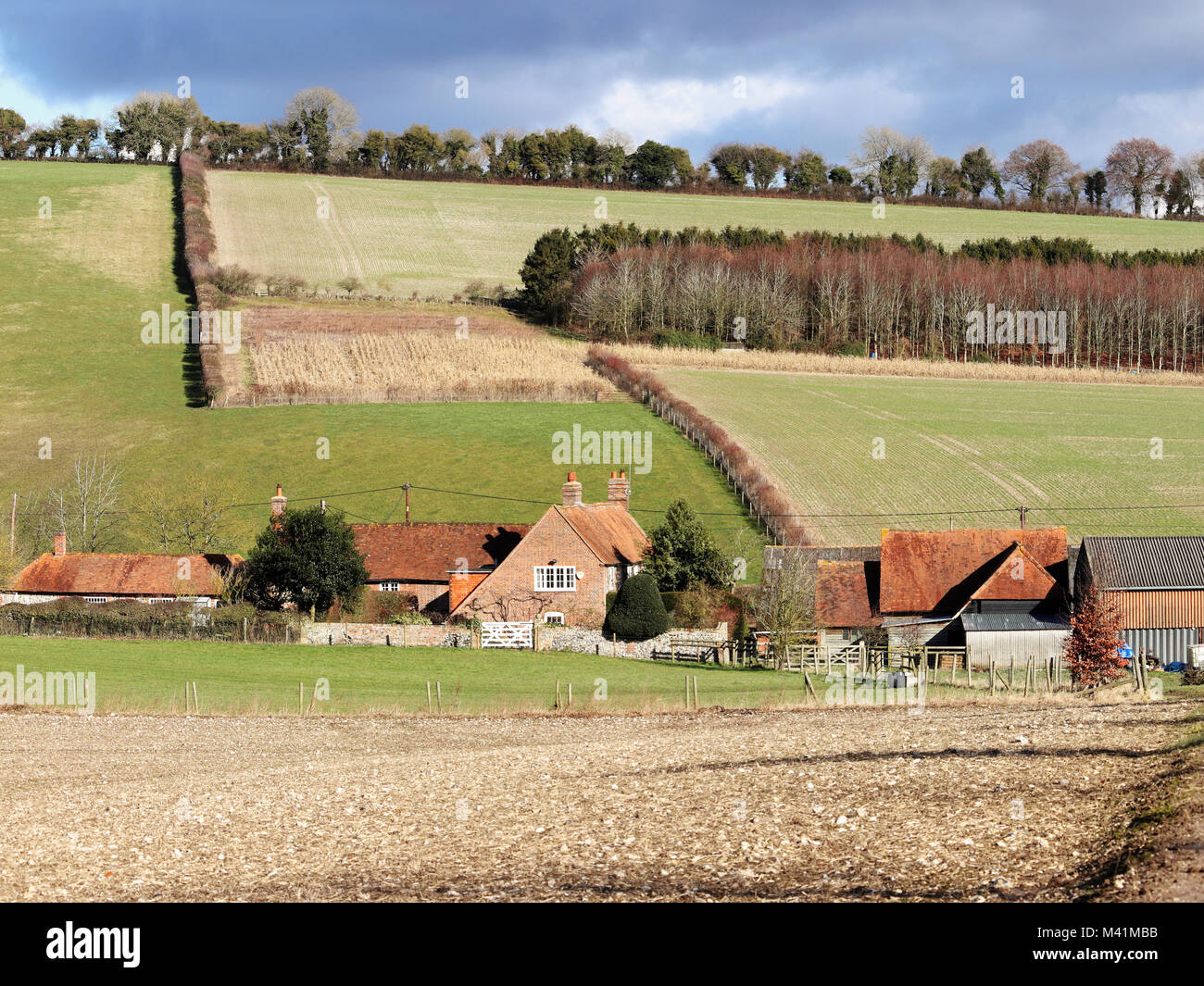 An English Rural Landscape in the Chiltern Hills in Winter sunshine with with Farmhouse in the Valley Stock Photo