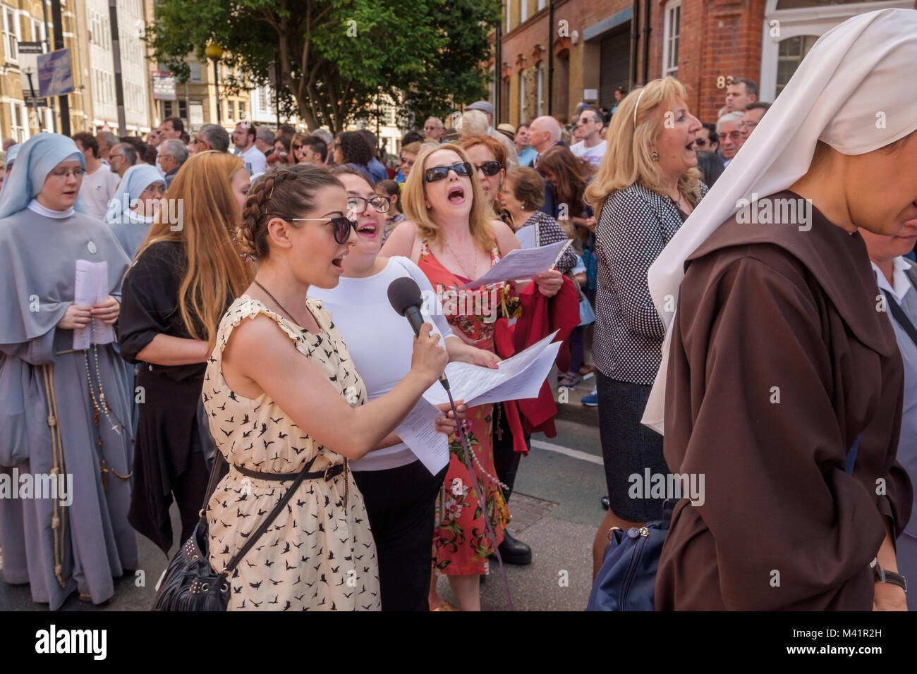 Three singers lead the singing as the parishoners start the procession around the area at the Festival of Our Lady of Mount Carmel at the Italian Church in Clerkenwell. Stock Photo