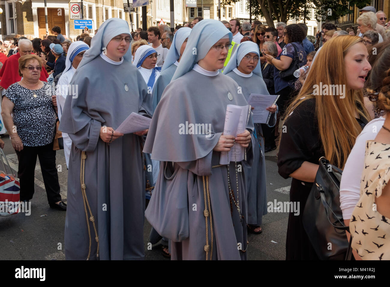 Nunds join in the singing at the Festival of Our Lady of Mount Carmel as the procession makes its way around the area close to the Italian Church in Clerkenwell. Stock Photo