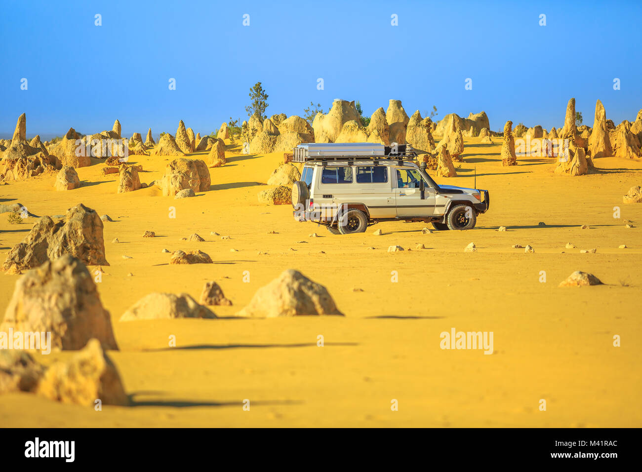 Four-wheel-drive car on Pinnacles Drive, dirt road in Pinnacles Desert, Nambung National Park, Western Australia. Discovery and adventure travel concept. Stock Photo