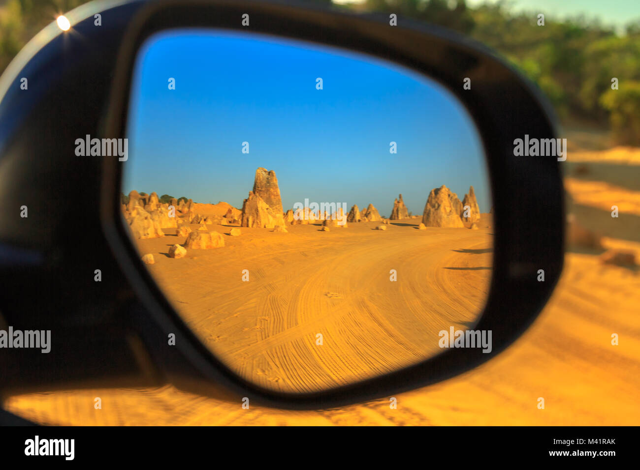 Dirt road of Pinnacles Desert Drive reflecting in the rearview mirror of a tourist car, Nambung National Park, Western Australia. Discovery and adventure tourism concept. Stock Photo