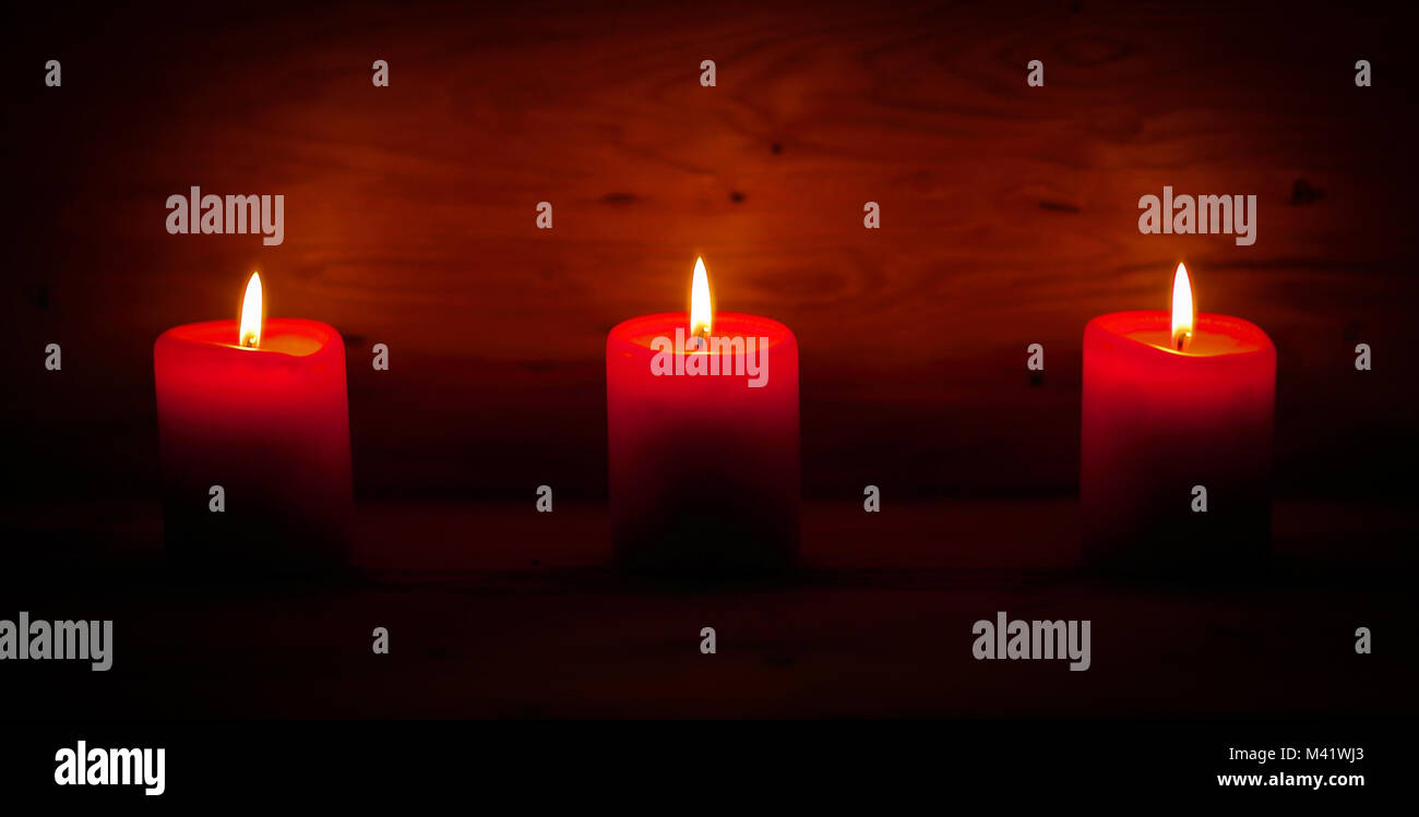 three candles on an abstract festive background Stock Photo - Alamy