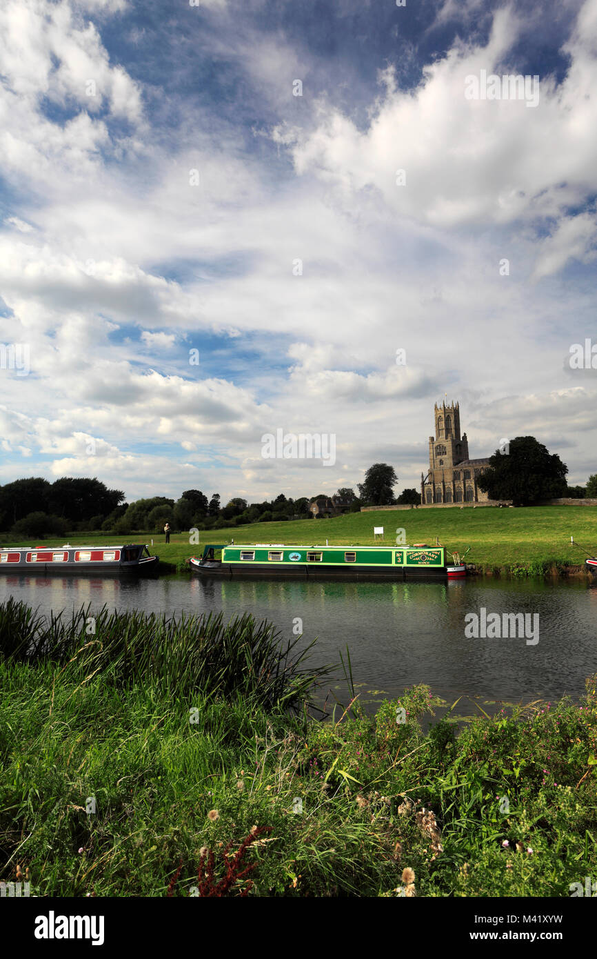 Narrowboats on the river Nene; St Mary and all Saints church; Fotheringhay village; Northamptonshire; England; UK Stock Photo