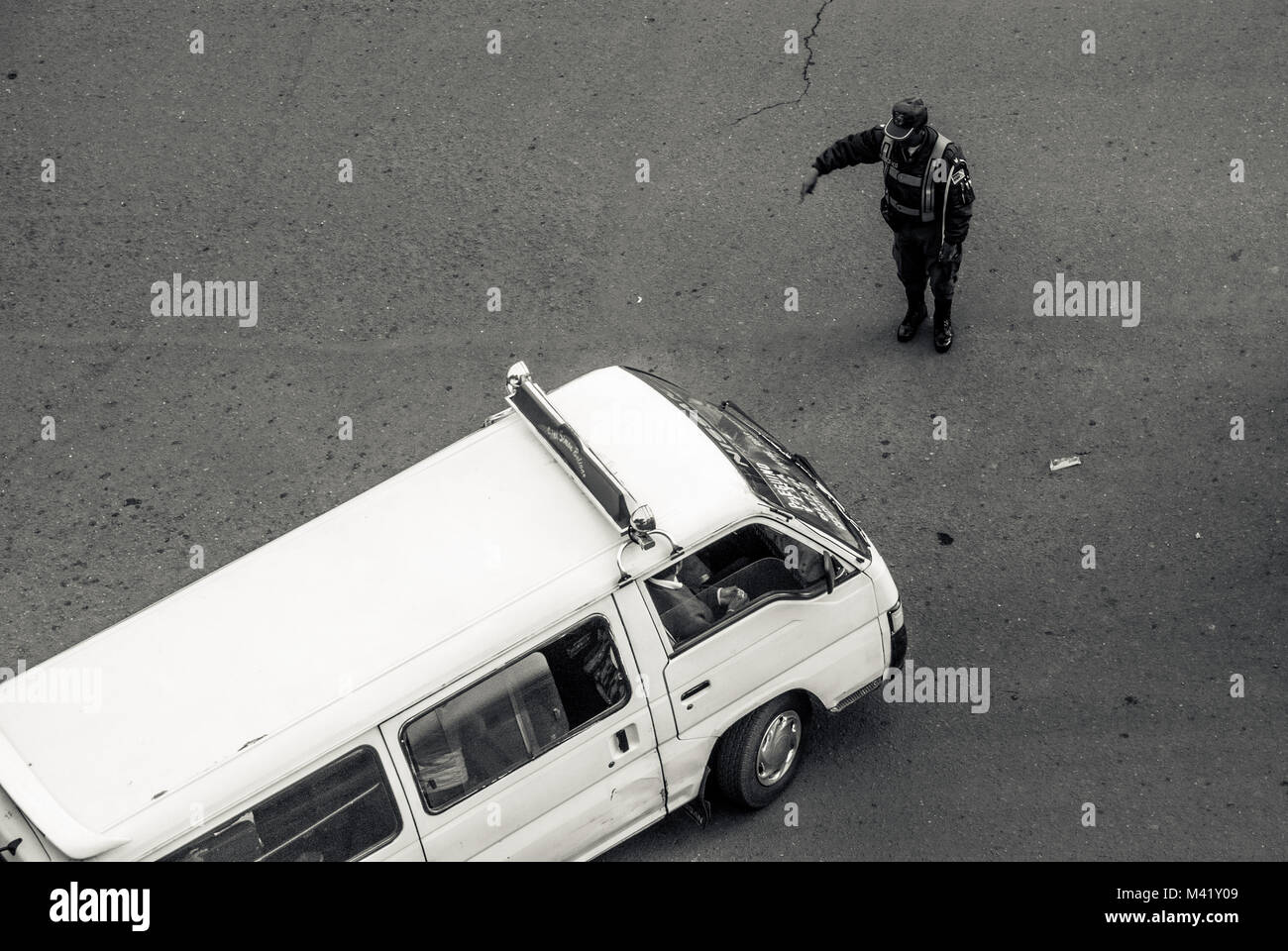 A black and white of a policeman directing traffic on a street in La Paz, Bolivia Stock Photo