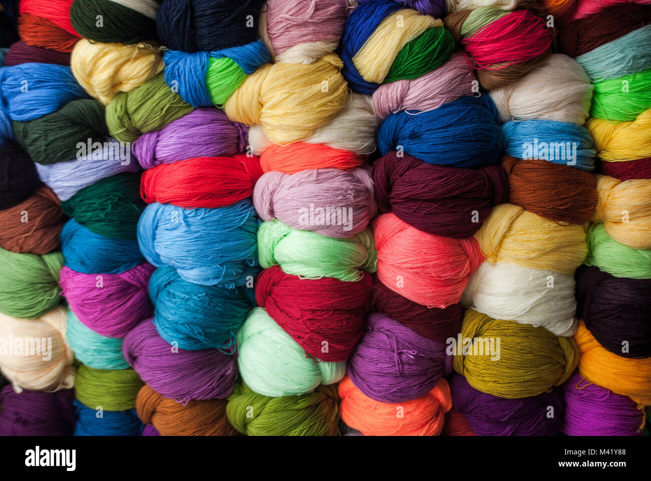 Lots of colorful balls of wool arranged together in a market Stock Photo