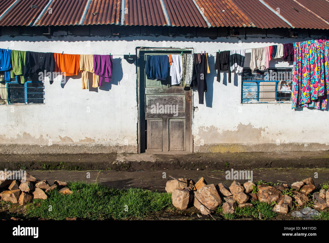 Clothes hanging out to dry in front of a rustic rural farmhouse with a corrugated iron roof Stock Photo