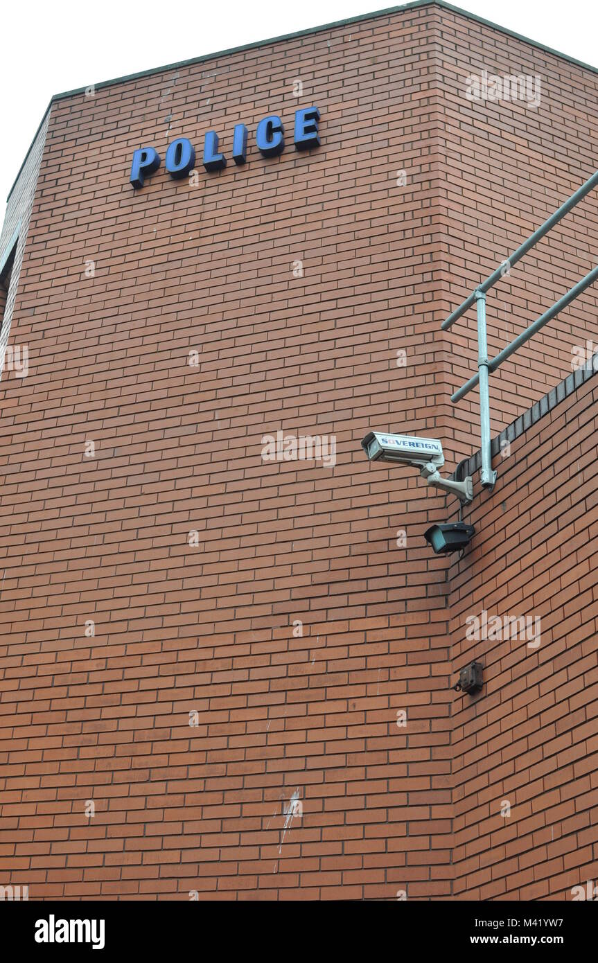 A CCTV surveillance camera mounted on the wall of a brick police station in Bristol, England Stock Photo