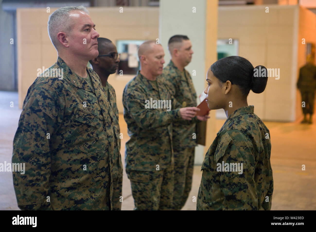 Brig. Gen. Daniel B. Conley, left, commanding general, 3rd Marine Logistics Group, presents Cpl. Nelfi Tineoferreiras, the noncommissioned officer-in-charge of Receiving Section, Supply Company, Combat Logistics Regiment 35, 3rd MLG, with the III Marine Expeditionary Force’s Marine of the Year at Camp Kinser, Okinawa, Japan, Feb. 8, 2018. Tineoferreiras was honored as III MEF’s Marine of the Year for being exemplary in her duties, which included her technical proficiency and demonstration of the Marine Corps' core values. Tineoferreiras is a native of the Dominican Republic and was recruited i Stock Photo