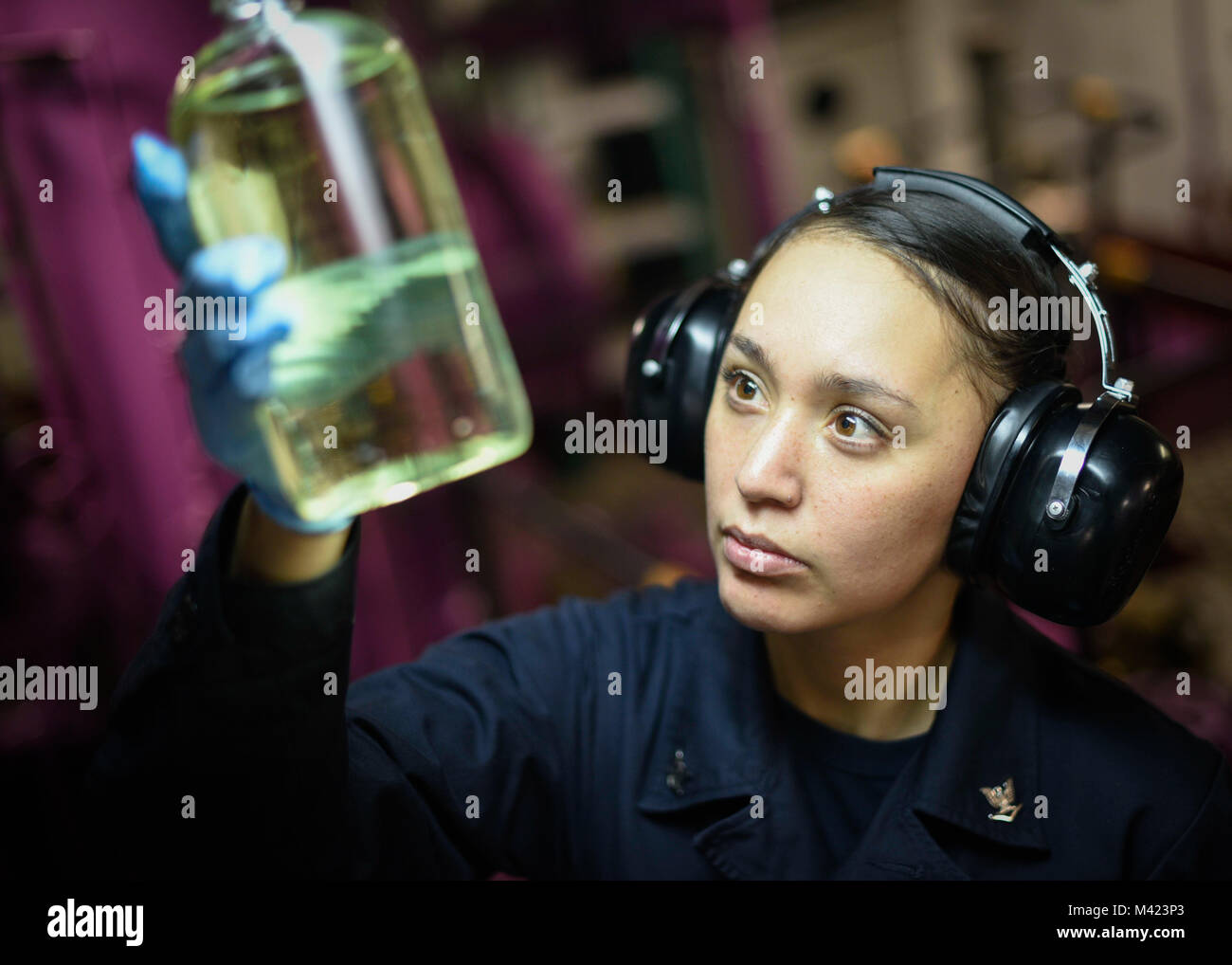 180208-N-NG033-2049 ARABIAN GULF (Feb. 8, 2018) Aviation Boatswain’s Mate (Fuel) 3rd Class Lena Santiago inspects a fuel sample aboard the aircraft carrier USS Theodore Roosevelt (CVN 71). Theodore Roosevelt and its carrier strike group are deployed to the U.S. 5th Fleet area of operations in support of maritime security operations to reassure allies and partners and preserve the freedom of navigation and the free flow of commerce in the region. (U.S. Navy photo by Mass Communication Specialist Seaman Michael Hogan/Released) Stock Photo