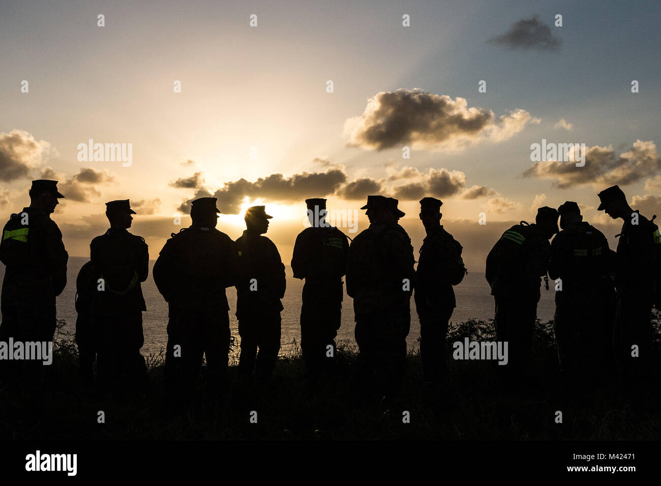 U.S. Marines assigned to Class 3-18 of the Marine Aircraft Group 24 Corporal's Course, watch the sunrise from the top Ulupa'u Crater prior to flying back to Marine Corps Air Station, Kaneohe Bay, Feb. 9, 2018. The course's graduation commenced after a hike across the crater. (U.S. Marine Corps Photo by Sgt. Aaron S. Patterson) Stock Photo