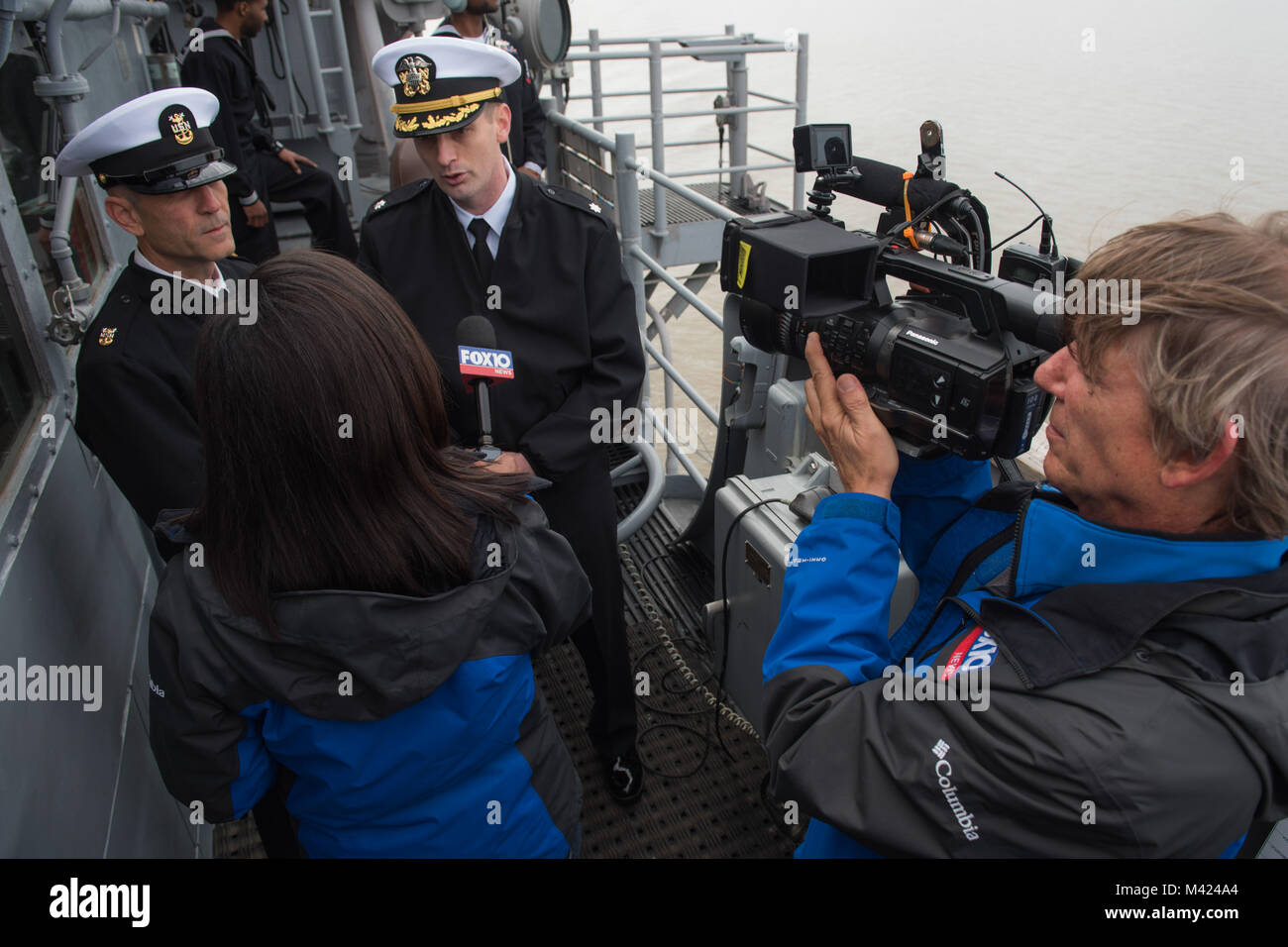 180209-N-DX615-090 MOBILE, Ala. (Feb. 9, 2018) Reporter Kendra Turley of Mobile’s Fox News 10 speaks with Cmdr. Jamie VanDyke, executive officer of the guided-missile cruiser USS Philippine Sea (CG 58), and Command Master Chief Jeffrey West as the ship transits Mobile Bay. Philippine Sea is participating in Mardi Gras celebrations during a scheduled port visit to Mobile. This visit provides area residents an opportunity to learn about the Navy. #USNavy #AmericasNavy  #ForgedByTheSea (U.S. Navy photo by Chief Mass Communication Specialist Alan Gragg) Stock Photo