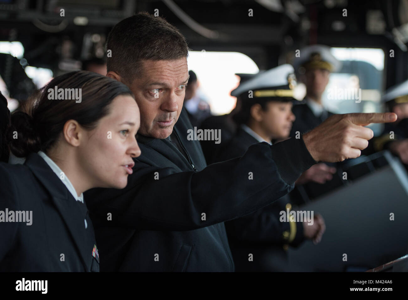 180209-N-DX615-172 MOBILE, Ala. (Feb. 9, 2018) Capt. Peter K. Nilsen, commanding officer of the guided-missile cruiser USS Philippine Sea (CG 58), works with Lt. j.g. Valerie Tucciarone, the ship’s navigation officer, while transiting Mobile Bay. Philippine Sea is participating in Mardi Gras celebrations during a scheduled port visit to Mobile, Ala. This visit provides area residents an opportunity to learn about the Navy. #USNavy #AmericasNavy  #ForgedByTheSea (U.S. Navy photo by Chief Mass Communication Specialist Alan Gragg) Stock Photo