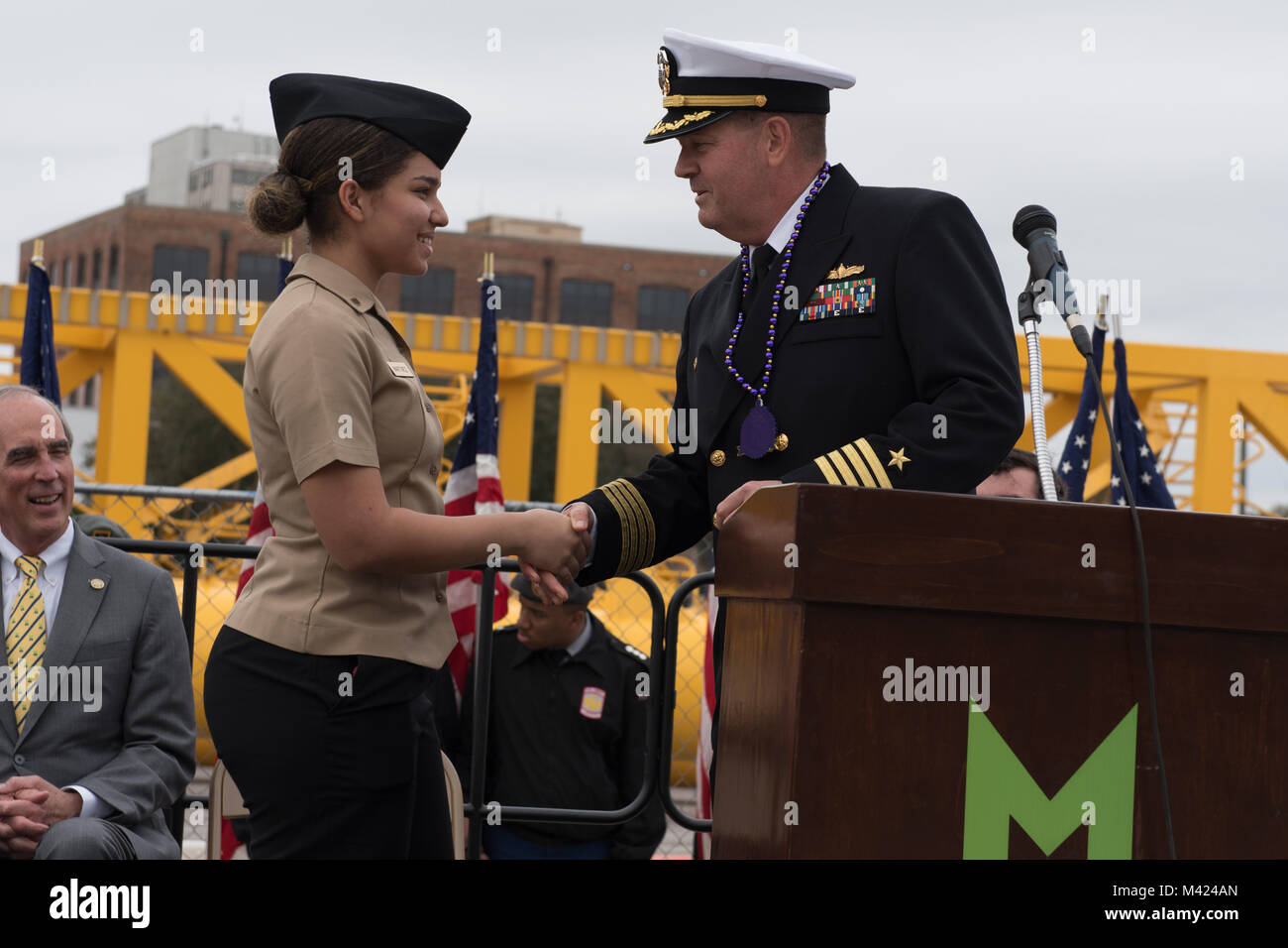 180209-N-FA806-109 MOBILE, Ala (Feb. 9, 2018) Capt. Peter K. Nilsen, commanding officer of the guided-missile cruiser USS Philippine Sea (CG 58),  hands Navy Junior Reserve Officer Training Corps cadet Shaneylitza Martinez a challenge coin during a ceremony celebrating Philippine Sea's arrival in Mobile, Ala. The ship is participating in Mardi Gras celebrations during a scheduled port visit, which provides area residents an opportunity to learn about the Navy. (U.S. Navy photo by Mass Communication Specialist 3rd Class Roland John) Stock Photo