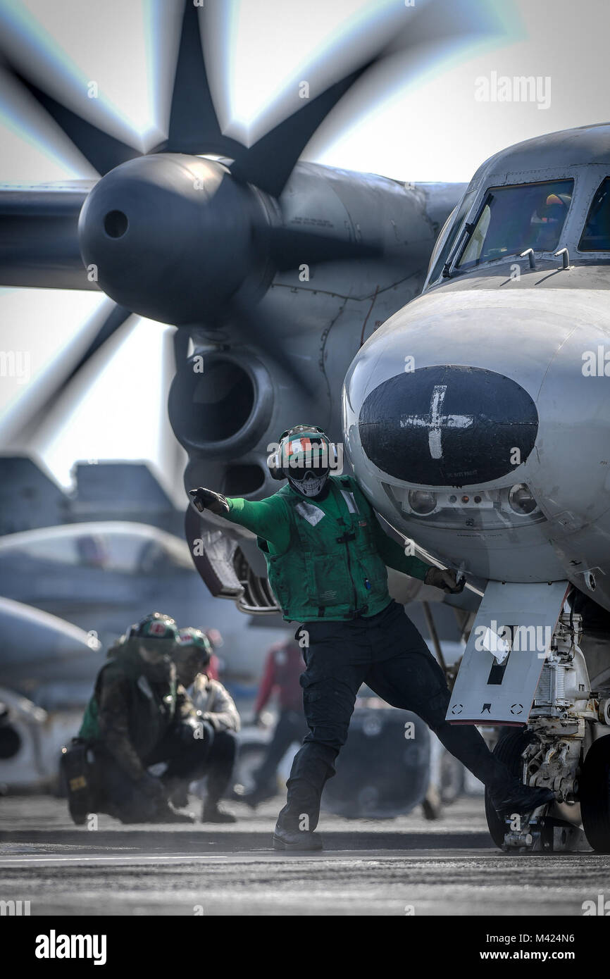 180210-N-MJ135-1044 ARABIAN GULF (Feb. 10, 2018) Aviation Boatswain’s Mate (Equipment) Airman Robert Rodriguez signals to launch an E-2C Hawkeye, assigned to the Sunkings of Carrier Airborne Early Warning Squadron (VAW) 116, on the flight deck of the aircraft carrier USS Theodore Roosevelt (CVN 71). Theodore Roosevelt and its carrier strike group are deployed to the U.S. 5th Fleet area of operations in support of maritime security operations to reassure allies and partners and preserve the freedom of navigation and the free flow of commerce in the region. (U.S. Navy photo by Mass Communication Stock Photo