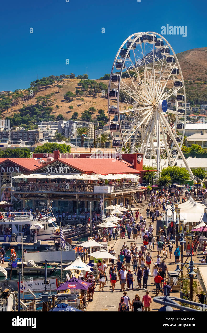 V&A Waterfront, Cape Town, South Africa, busy with people shopping at Cape Union Mart and the Cape Wheel in summer Stock Photo