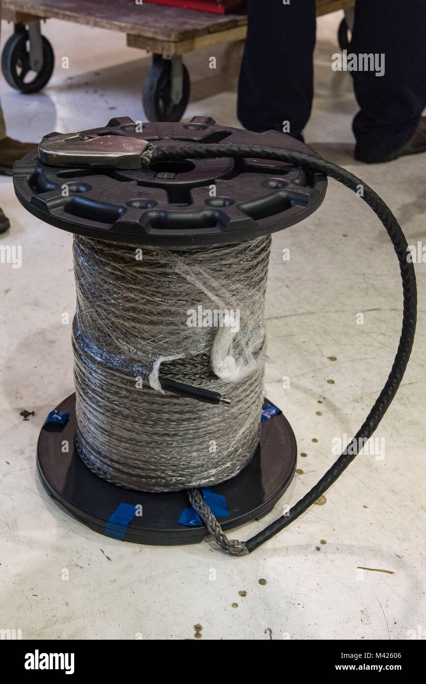 Application engineers from Samson Rope, Ferndale, Wash., brought the proposed synthetic winch cable for C-17 Globemaster III maintainers to wind on a winch assembly, Jan. 30, 2018, at Dover Air Force Base, Del. The 280-foot synthetic winch cable weighs 14 pounds and is 83 percent lighter than the current 80 pound steel wire cable. (U.S. Air Force photo by Roland Balik) Stock Photo