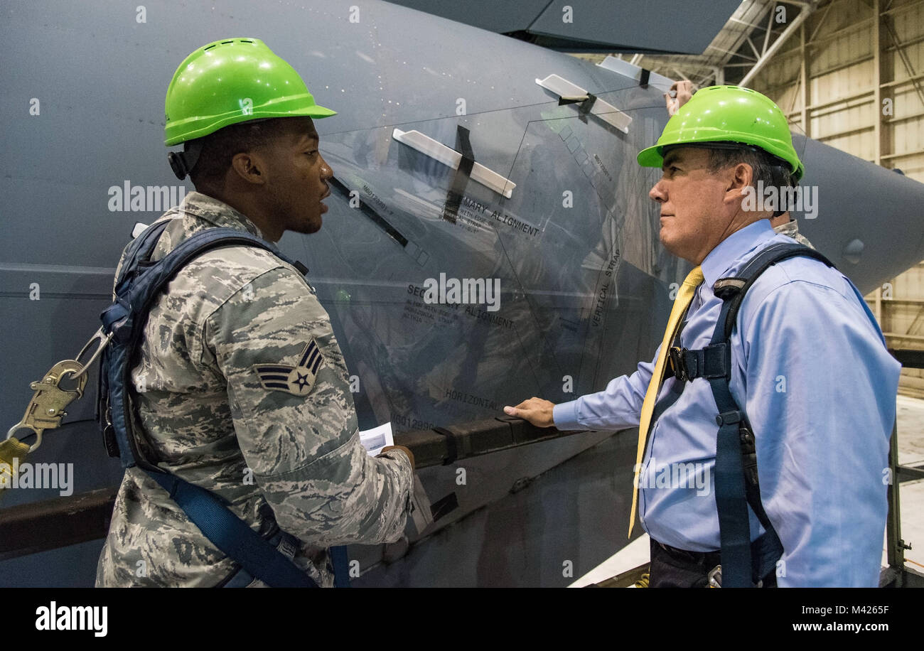 Senior Airman Terrence Williamson, 736th Aircraft Maintenance Squadron aerospace maintenance journeyman, explains to Roberto Guerrero, Deputy Assistant Secretary of the Air Force for Operational Energy, Headquarters U.S. Air Force, Washington, D.C., how Microvanes positioned on each side at the rear of a C-17 Globemaster III fuselage using a Mylar template, Sept. 6, 2017, at Dover Air Force Base, Del. Microvanes essentially clean up the airflow in the region of the cargo door by re-energizing the air with small vortices that delay separation, smooth the flow, and reduce drag. “The programs APT Stock Photo