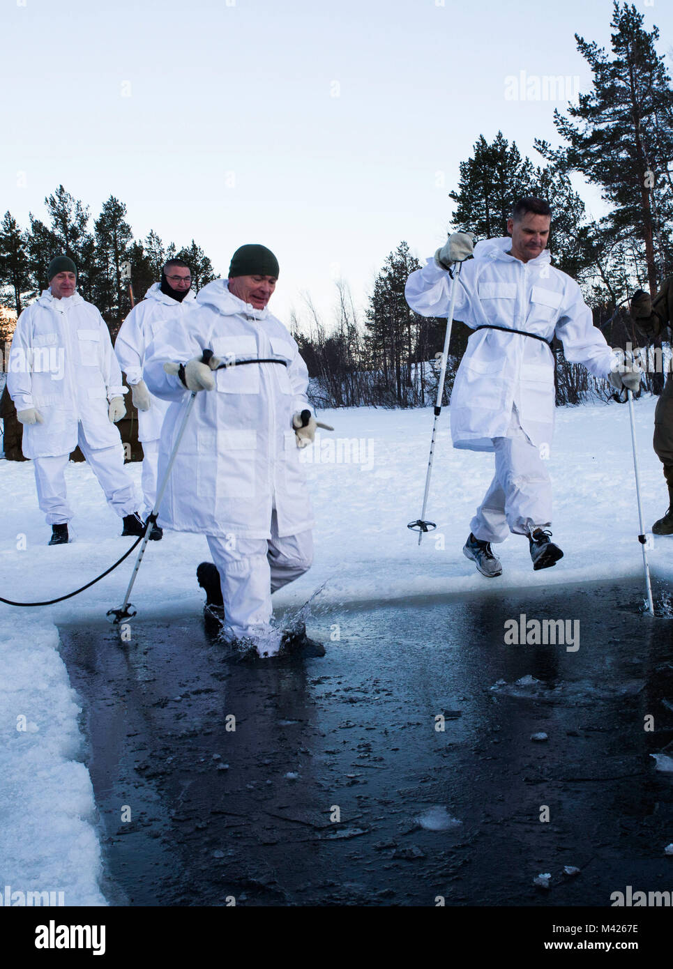 Norwegian Maj.Gen. Odin Johannessen, the chief of Norwegian Army, participates in an ice-breaking drill alongside Maj.Gen. Russell A.C. Sanborn, the commander of Marine Corps Forces Europe and Africa, in Bardufoss, Norway, Jan. 31, 2018. Sanborn participated in this training evolution to experience the training the Marines have endured throughout their time in Norway. The drill is a cornerstone of advanced cold-weather training, intended to teach a service member the immediate steps to take when falling in ice. (U.S. Marine Corps photo by Cpl. Careaf L. Henson/Released) Stock Photo