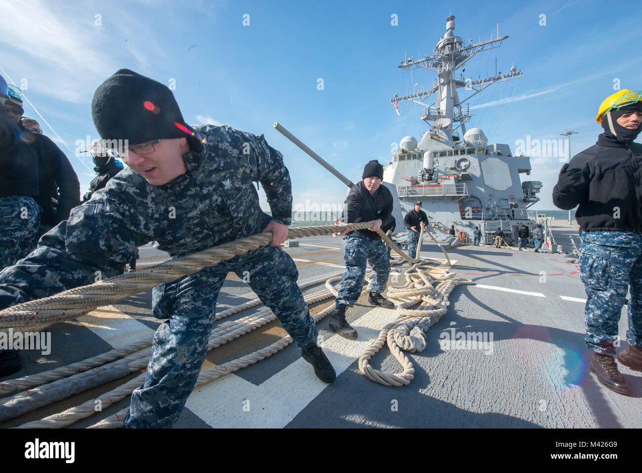 180201-N-ZU710-061  Atlantic Ocean (Feb. 1, 2018) Sailors haul in mooring lines aboard the USS Winston S. Churchill (DDG-81) while pulling out of Naval Station Norfolk to conduct a Composite Training Unit Exercise (COMPTUEX). USS Winston S. Churchill is underway as part of the Harry S. Truman Carrier Strike Group (HSTCSG) COMPTUEX, which evaluates the strike group's ability as a whole to carry out sustained combat operations from the sea, ultimately certifying the HSTCSG for deployment. (U.S. Navy Photo by Mass Communication Specialist 3rd Class Michael Chen/Released) Stock Photo