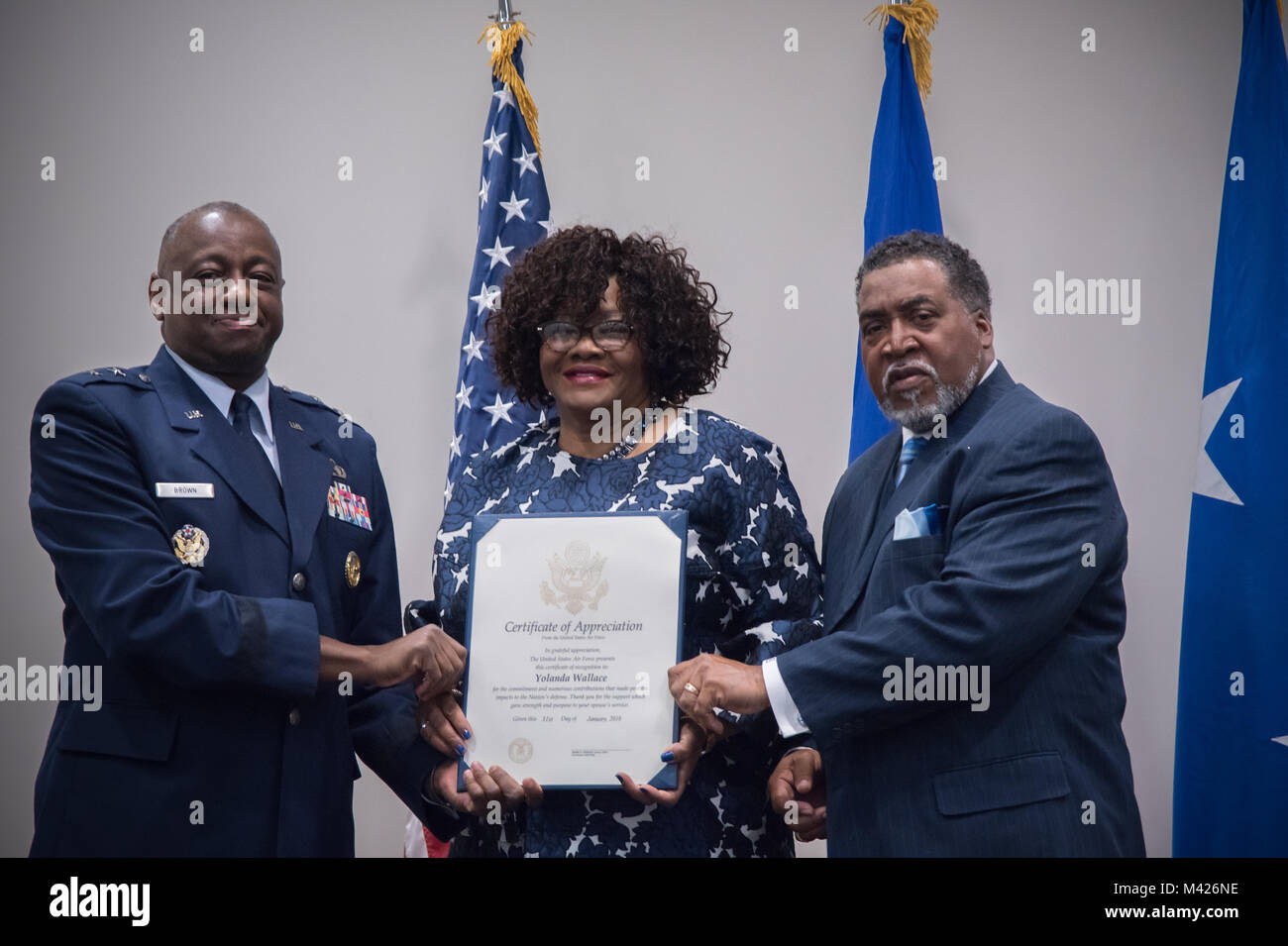Maj. Gen. Mark Brown, Air Education and Training Command deputy commander, Gary Wallace, 53rd Weather Reconnaissance Squadron aviation resource management technician, present a certificate of appreciation to Wallace's wife, YoLanda Wallace, 81st Mission Support Group, during Gary Wallace's retirement ceremony Feb. 2, 2018 at Keesler Air Force Base, Mississippi. (U.S. Air Force photo by Staff Sgt. Heather Heiney) Stock Photo