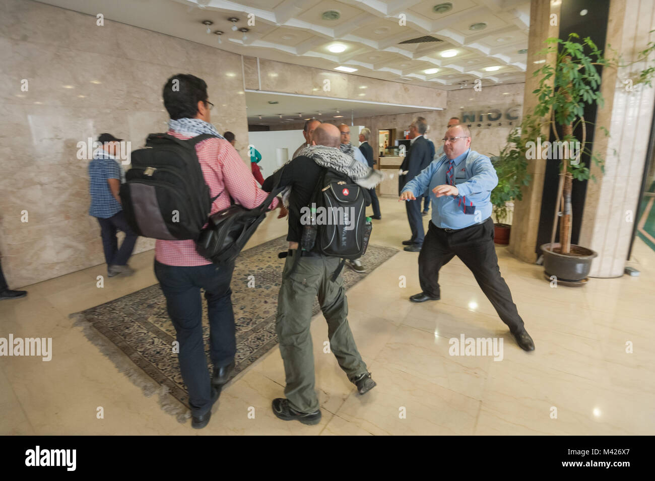 Security tried to stop the protesters but there were too many and most rushed past them, making for the stains and the secret UK-Iran business meeting on the sixth floor. Stock Photo
