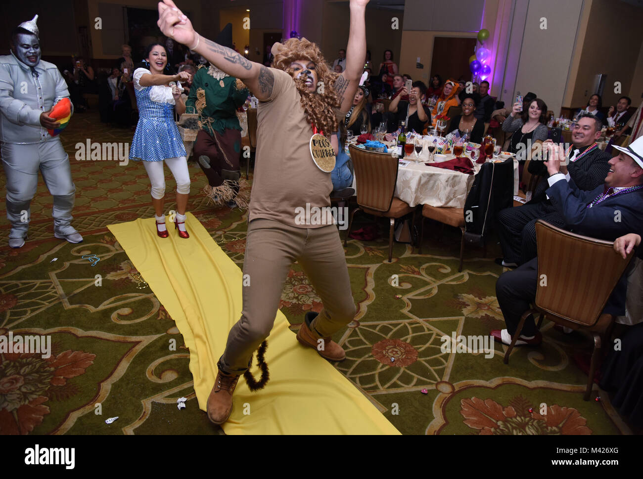 Senior Airman Rashawn Thompson, 81st Medical Operations Squadron mental health technician, dressed as the Cowardly Lion from The Wizard of Oz, dances down the aisle during a Mardi Gras float contest at the 30th Annual Krewe of Medics Mardi Gras Ball at the Bay Breeze Event Center Feb. 3, 2018, on Keesler Air Force Base, Mississippi. The Krewe of Medics hosts a yearly ball to give Keesler Medical Center personnel a taste of the Gulf Coast and an opportunity to experience a traditional Mardi Gras. The theme for this year's ball was Read It-Be It. The 81st MDOS won first place in the float contes Stock Photo