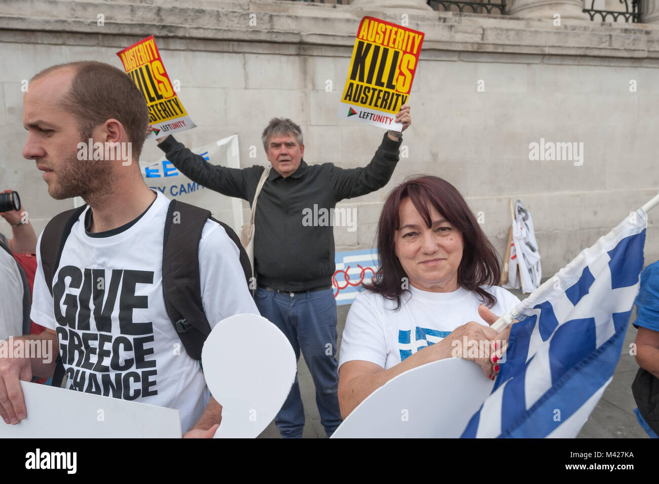 Andrew Burgin of Left Unity holds up two posters 'Austerity Kills' at the Trafalgar Square protest in a European week of solidarity for Greece. Stock Photo