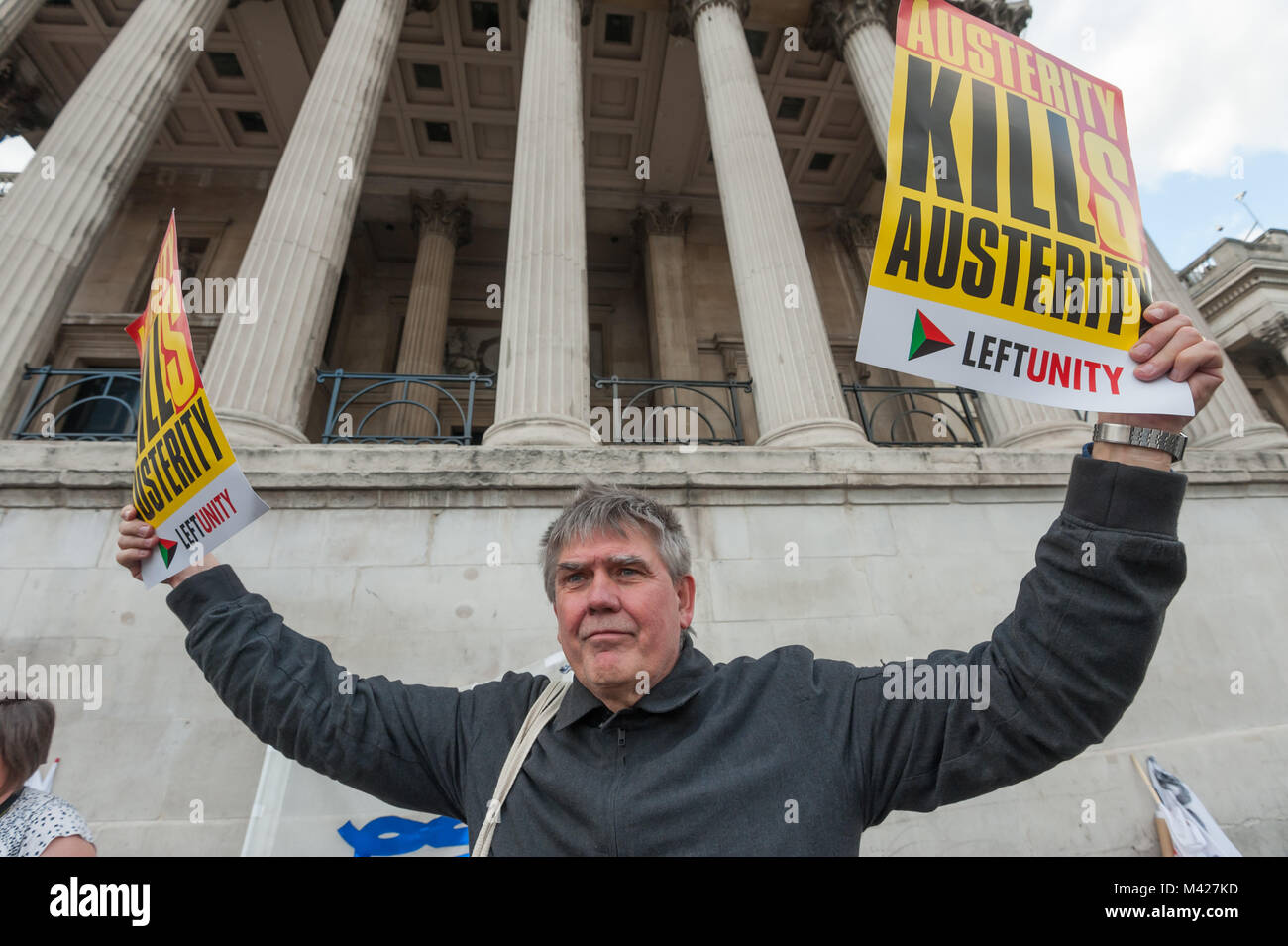 Andrew Burgin of Left Unity holds up two posters 'Austerity Kills' at the Trafalgar Square protest in a European week of solidarity for Greece. Stock Photo